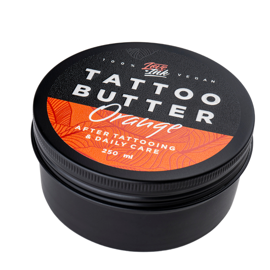 Close-up of a 250ml jar of Tattoo Butter Orange by LoveInk. The product features a black and orange design, emphasizing its use for after tattooing and daily care.