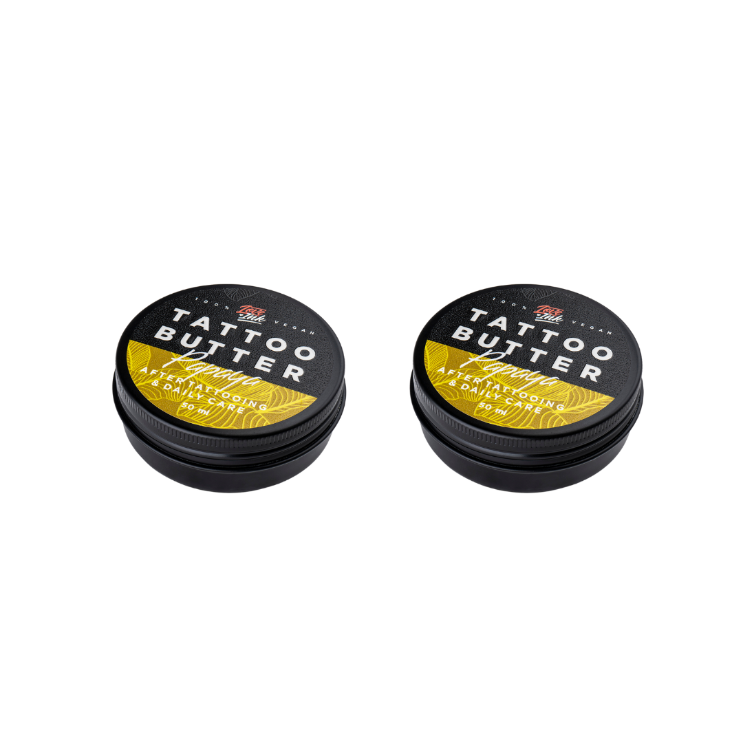 Two tins of Love Ink Tattoo Butter on a transparent background. Both tins are labeled 'Tattoo Butter Papaya" with an yellow design