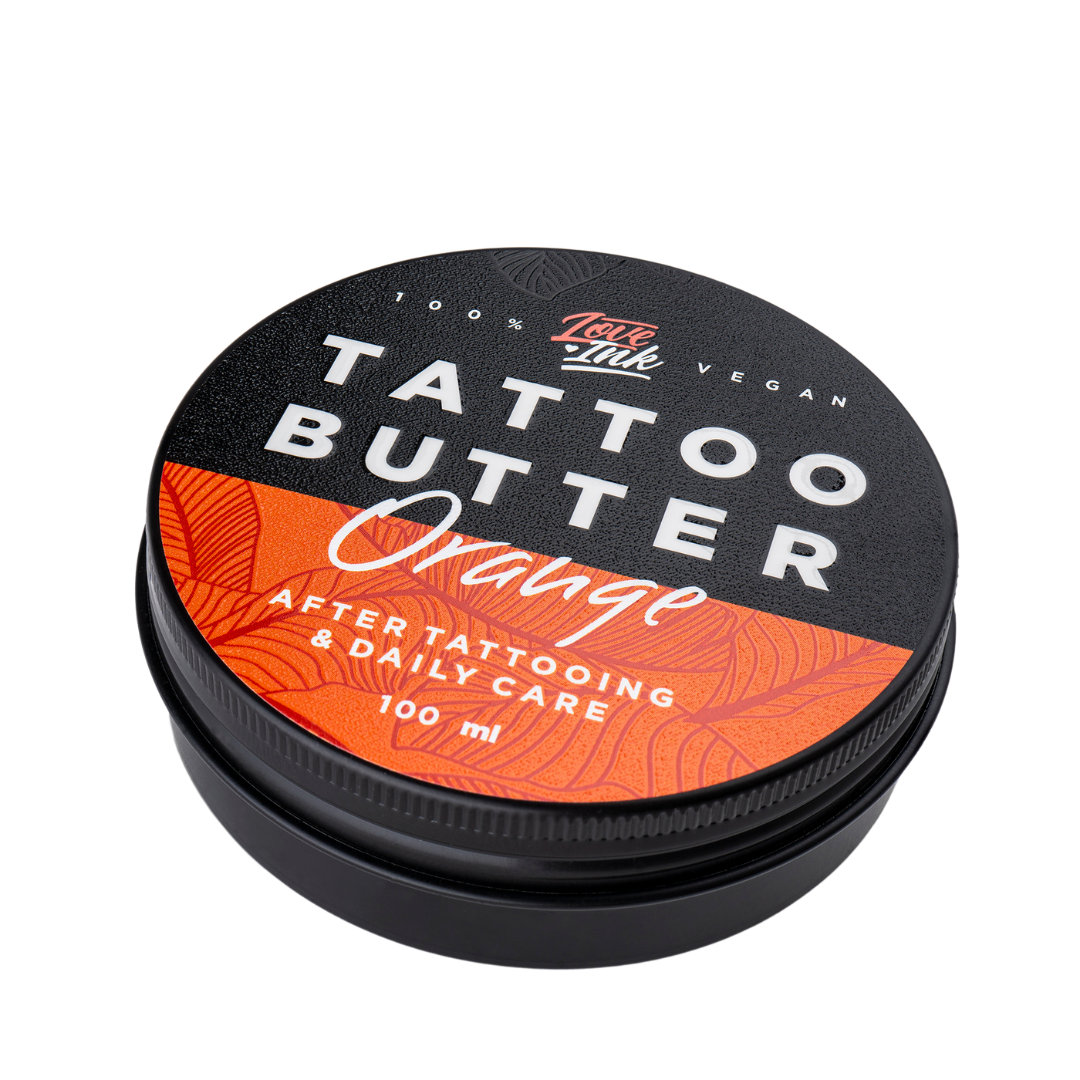 Close-up of a jar of Tattoo Butter Orange by LoveInk. The sleek black and orange packaging highlights its purpose for after tattooing and daily care, 100ml size.