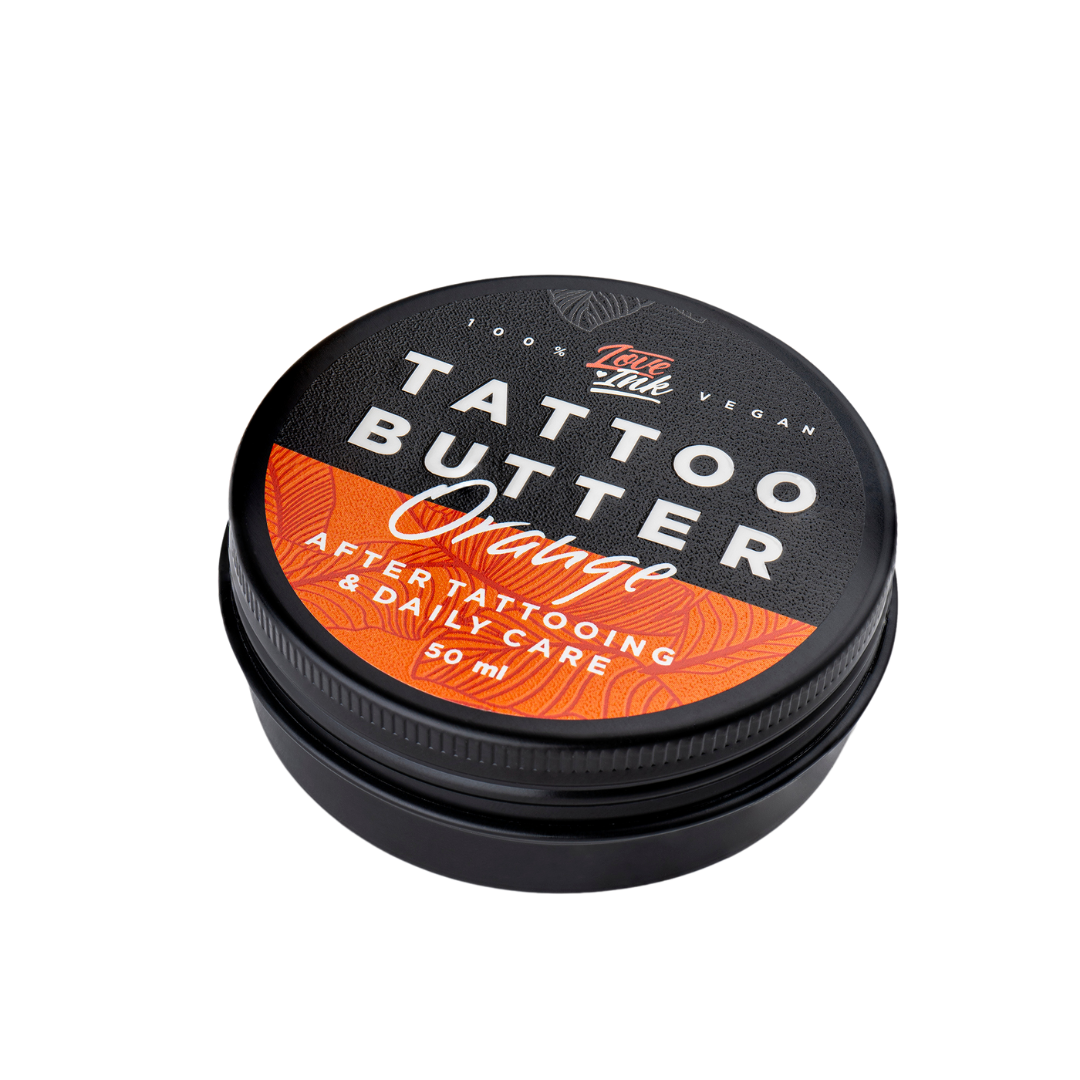 Close-up of a 50ml jar of Tattoo Butter Orange by LoveInk. The product features a black and orange design, emphasizing its use for after tattooing and daily care.