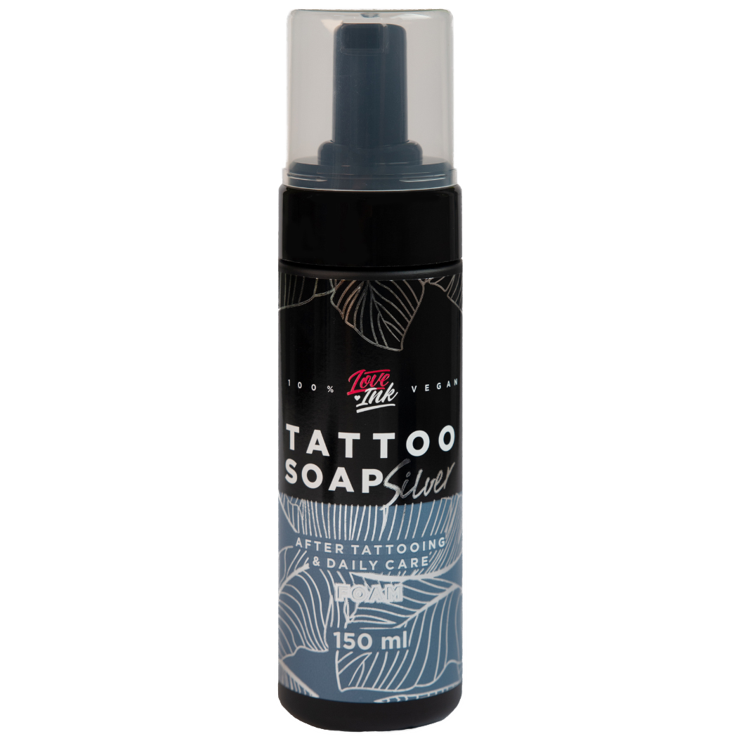 Image of LoveInk's Tattoo Soap Silver bottle containing 150ml of foam for tattoo care. The black bottle features white and silver botanical designs with a clear cap.